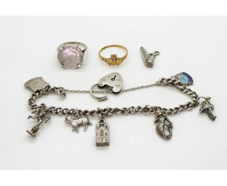 A 9ct gold Claddagh ring, size O1/2, and a silver charm bracelet with seven silver and white metal charms, to include two ena