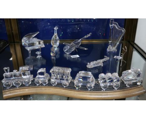 A Swarovski crystal train on track, together with musical instruments including a piano, mandolin, violin, saxophone and harp