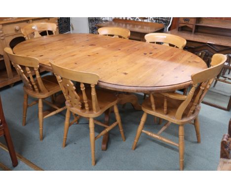 A 20th century pine extending dining table and six chairs, table oval extending top with single leaf on twin pedestal base jo