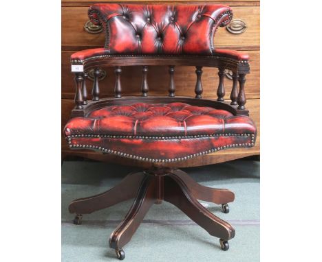 A 20th century oxblood leather button back upholstered captains style swivel desk chair, 80cm high x 63cm wide x 63cm deep Co