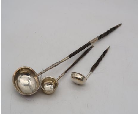 A Georgian silver toddy ladle, with a turned whalebone handle, 35cm long, and two smaller white metal ladles (3) Condition Re