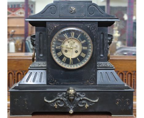 A lot comprising an early 20th century black slate mantel clock with skeletonised dial bearing gilt Roman numerals, 17cm diam
