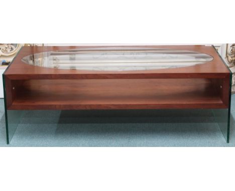 A mid/late 20th century stained teak and glass coffee table with oval glass inset top over shelf on glass ends, 40cm high x 1