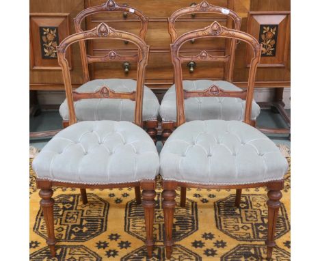 A set of four Victorian Walnut framed parlour chairs with carved back rests over button upholstered seats on turned tapering 