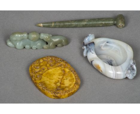 A Chinese carved jade model Formed as two mythical beasts and a ball; together with a jade pin shaped pendant; a butterscotch