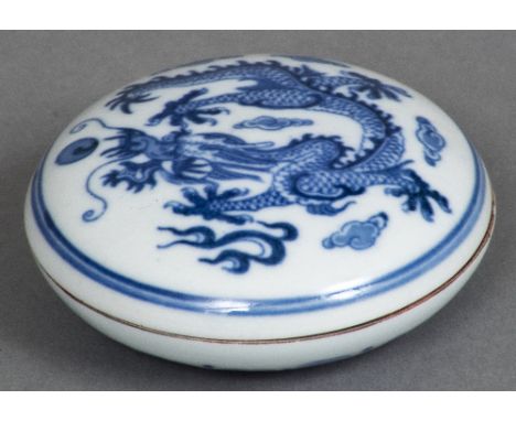 A Chinese blue and white porcelain seal boxOf lidded circular form, the top decorated with a five clawed dragon chasing a pea