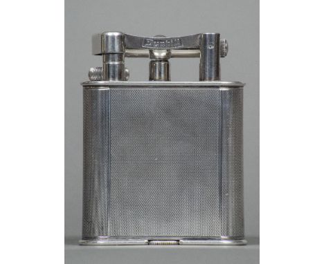 A silver plated Dunhill table lighterOf typical engine turned form, the underside with patent number 390107.  10.5 cm high.  