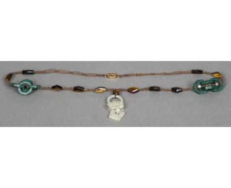 An intricately carved Chinese puzzle necklaceSet with white jade, malachite and tigers eye, with a silver gilt filigree clasp
