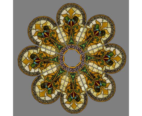 A stained glass roundelComprising eight panels, each with scrolling foliate design.  Each panel approximately 75 x 120 cm.   