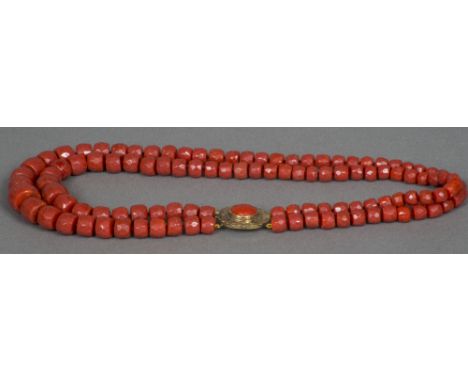 A two string facet cut coral bead necklaceSet with a coral mounted 18 K gold clasp.  Approximately 57 cm long.    CONDITION R