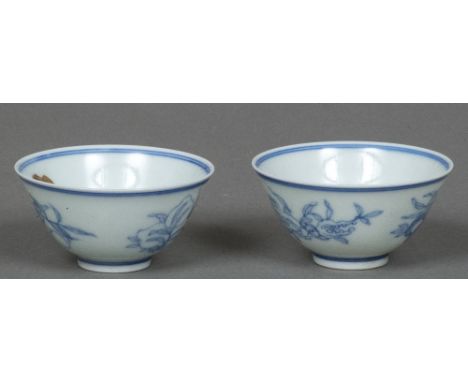 A pair of Chinese blue and white porcelain tea bowlsEach decorated with fruiting sprays and standing on a shallow foot, blue 