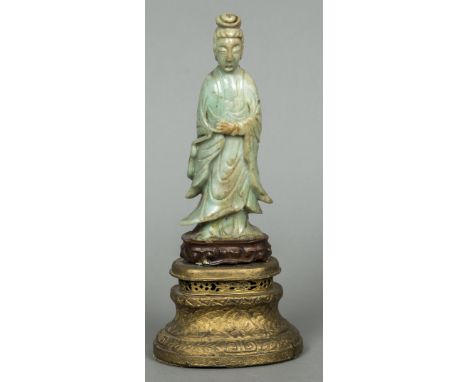 An antique Chinese jade carving of GuanyinTypically modelled wearing flowing robes, mounted on a wooden display plinth and a 