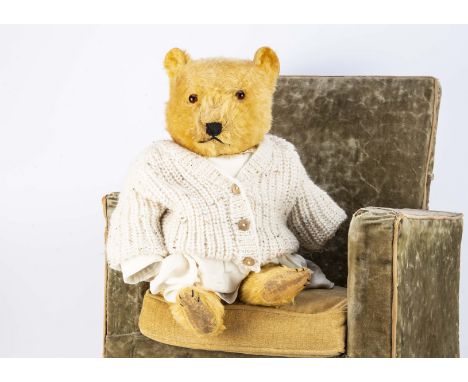 A Chiltern Hugmee post-war teddy bear, with golden mohair, orange and black glass eyes, black stitched nose, swivel head, joi