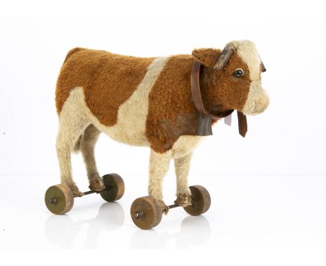 A 1920s Steiff cow on wheels,  with brown and white mohair, black boot button eyes with white felt disc behind, kid leather h