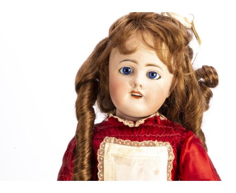 A Limoges child doll,  with fixed blue glass eyes, recent brown wig, jointed composition body, red dress and shoes with white