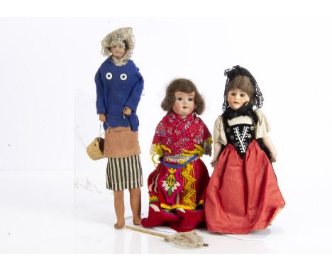 Three bisque headed dolls in European costumes, a Gebruder Heubach 7711 character with brown sleeping eyes, jointed compositi