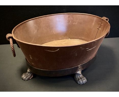 An oval iron planter, ring loop handles, paw feet, 24cm high, 58cm wide. 