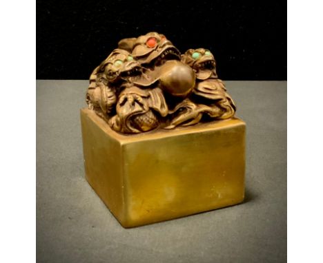 A Gilt bronzed metal Chinese dragon seal, with green and red cabochon eyes, approx 10cm x 7cm. 