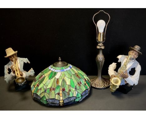 A Tiffany style lamp, leaded shade decorated green shade with a border of dragonflies, 60cm high ; a pair of jazz figures (3)