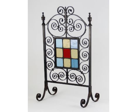 An Arts &amp; Crafts style firescreen, early 20th century, the central leaded coloured glass panel set to a scrolling wrought