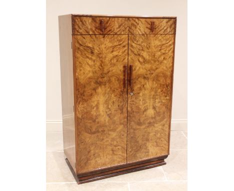 An Art Deco figured walnut gentleman's wardrobe, the quarter veneered top above a single drawer and a pair of doors opening t