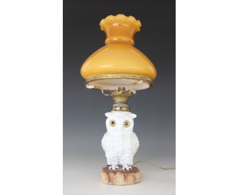 A Staffordshire porcelain oil lamp modelled as a white owl, 19th century, the body forming the reservoir below a threaded bur