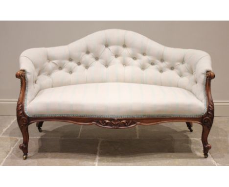 A Victorian carved walnut and upholstered sofa, of diminutive proportions, later re-covered in striped fabric, the arched but