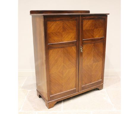 An Edwardian gentleman's mahogany 'The Valet' fitted wardrobe, the pair of panelled doors opening to a an arrangement of draw