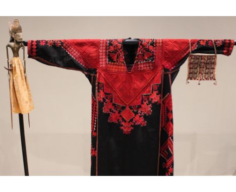 A Syrian thobe embroidered with red geometric patterns against a black ground, 139cm long, with a woven Peruvian purse decora