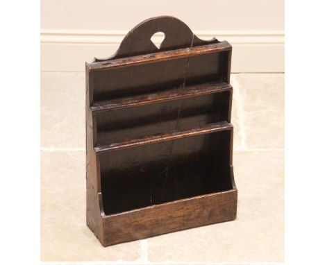 An 18th century oak Welsh wall hanging spoon rack, with three stepped and pierced tiers above the lower trough, 56cm H x 38cm