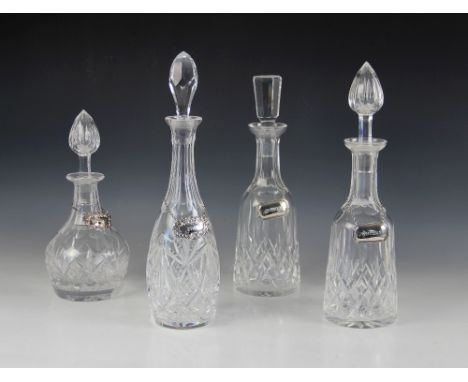 Four early 20th century cut glass decanters with associated stoppers, measuring between (excluding stoppers) 18.5cm and 29cm,