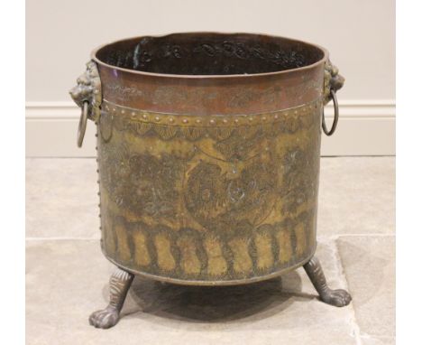 A brass and copper log bin, early 20th century, of cylindrical form, applied with lion mask ring handles and rivet detail, em