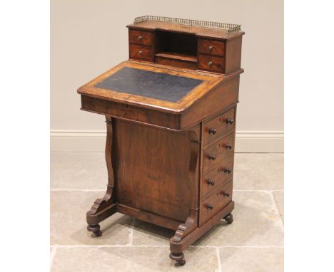 A Victorian figured walnut davenport, the raised back with a three quarter brass gallery over a hinged stationery compartment