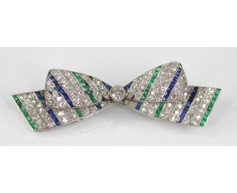 An Art Deco diamond, sapphire and emerald bow brooch, the central round old cut diamond weighing approximately 0.20 - 0.25 ca