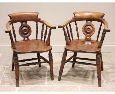 A near pair of Victorian elm and beech smokers bow elbow chairs, each with a roundel splat and turned supports over a shaped 