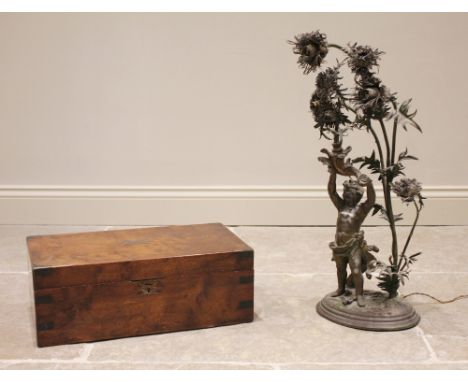 An early 20th century spelter figural table lamp, modelled as a cherub arms aloft within a chrysanthemum plant, the flower he
