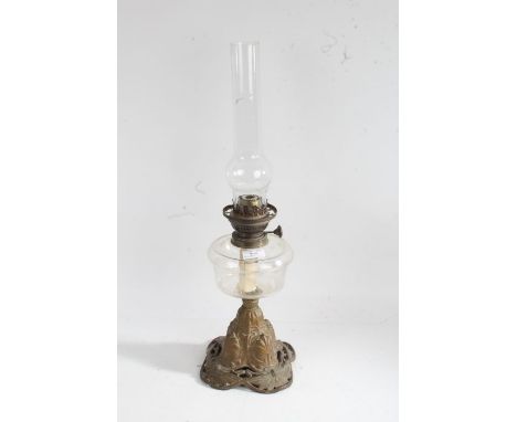 Art Nouveau cast metal based oil lamp, the glass chimney above a clear glass reservoir, raised on a gilded metal base with st