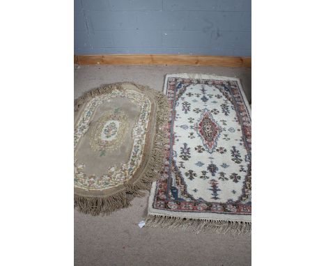 Two 20th century Indian rugs, both with light colourings, one with rounded ends, the largest 184cm by 93cm&nbsp;
