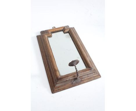 17th century style oak wall mirror, the shaped mirror plate housed in a stepped frame with iron pricket candlestick to the lo