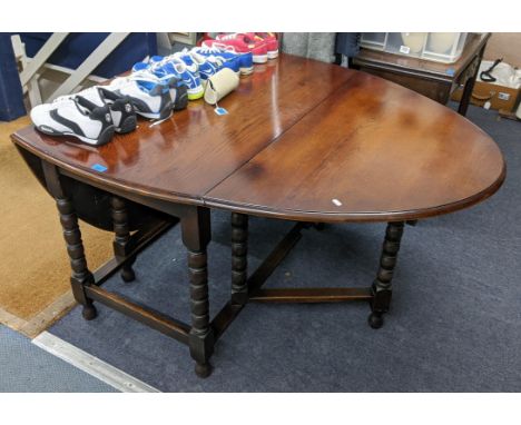 An early 20th century oak gateleg table having bobbin turned supports and two fall flaps, 73cm h x 114cm wLocation: 