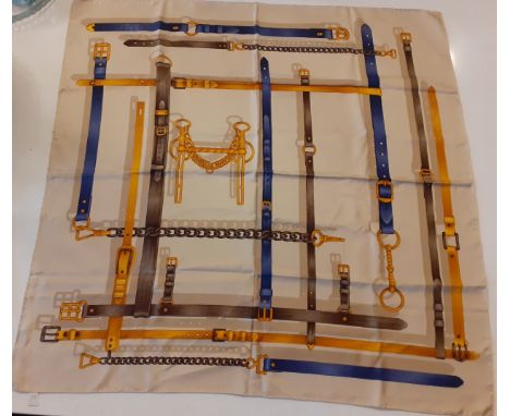 Gucci- A late 20th Century silk scarf having a tan ground with images of horse leathers, belts and stirrup in a brown, orange