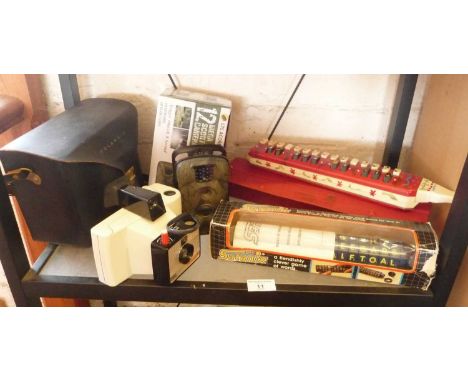 Polaroid Swinger camera model 20, a Hohner Melodica-Alto, an LTL Acorn Scouting camera and a Satanix word game