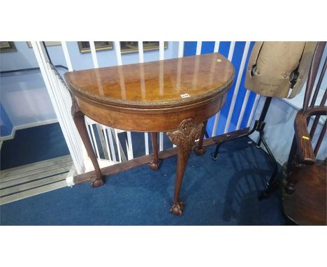 A walnut demi lune fold over card table, with claw and ball feet, 83cm wide