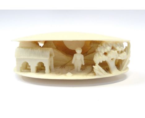 VINTAGE EAST ASIAN CARVED IVORY CLAMSHELLwith figure in landscape setting, 2.8cm high and 7.8cm wide, with fitted box