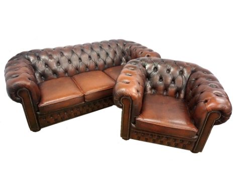 CHESTERFIELD THREE SEAT SOFAwith a button back, scroll arms above three seat cushions, with decorative stud work, standing on