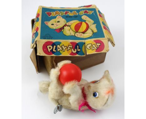 A vintage Japanese tin plate wind-up toy cat with ball.