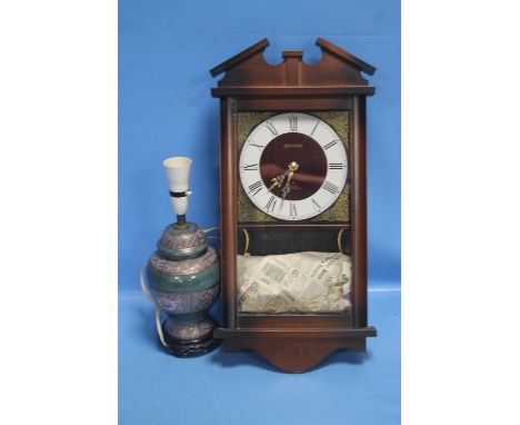 A HANGING WALL CLOCK TOGETHER WITH A LAMP