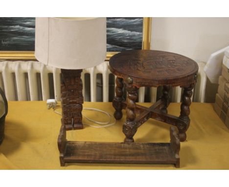 A VINTAGE LEATHER TOPPED TABLE TOGETHER WITH A CARVED WOODEN LAMP AND A BOOK SLIDE