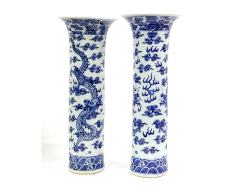 A Pair of Chinese Porcelain Sleeve Vases, 19th century, painted in underglaze blue, each with a pair of dragons chasing a fla
