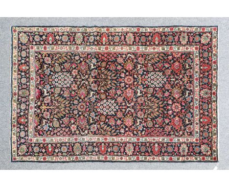 Tabriz CarpetNorth West Iran, circa 1930The indigo field with a one way design of birds trees and plants enclosed by borders 